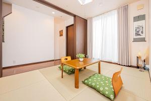 un soggiorno con un tavolo e una sedia di Fukuei Stay Premium a Tokyo