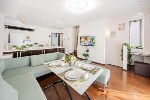 un soggiorno con un divano blu e un tavolo di Fukuei Stay Premium a Tokyo