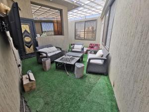 a room with chairs and a table and green carpet at راحتي in Al Baha