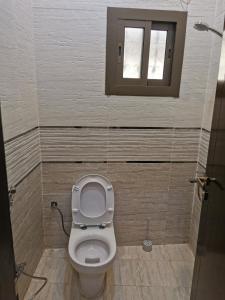 a bathroom with a toilet and a window at راحتي in Al Baha +7 photos