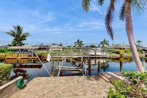 a marina with a dock and a palm tree at Palm Hideaway in Cape Coral