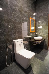 a bathroom with a toilet and a sink at Cinnamon Forest Resort - Hikkaduwa in Beratuduwa +50 photos