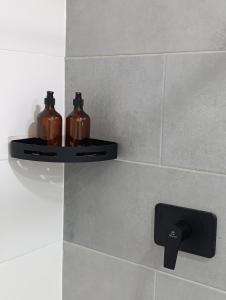 two bottles on a shelf on a bathroom wall at Bluelux Med - B&B in Medellín +70 photos