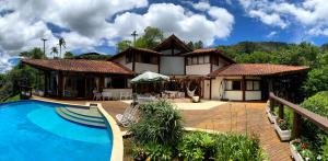 a house with a swimming pool in front of it at Suíte em Condomínio de Luxo em Casa de Família in Araras Petropolis