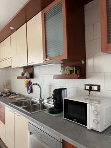 una cocina con fregadero y microondas en B&B Ginevra, en Taranto