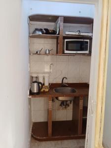 eine kleine Küche mit Spüle und Mikrowelle in der Unterkunft studio 1 or 2 1bed room sea view by the pool green beach v114 in El-Alamein