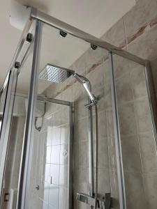 una ducha con puerta de cristal en un baño en B&B Ginevra, en Taranto