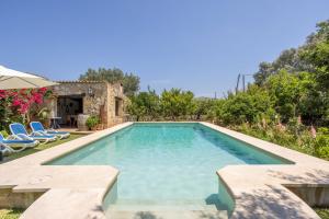 ein Swimmingpool in einem Hof mit Stühlen und Bäumen in der Unterkunft Villa Can Boseta by SunVillas Mallorca in Pollença
