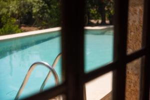 Blick auf den Pool durch ein Fenster in der Unterkunft Villa Can Boseta by SunVillas Mallorca in Pollença