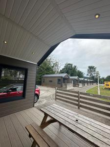 a wooden bench sitting on the porch of a building at Self-Catering Lodge with Hot Tub in Inverness