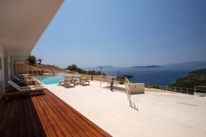 a balcony with a pool and a view of the ocean at 2S Villas Resort - Cave Villas in Sivota