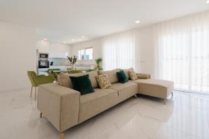 uma sala de estar com um sofá e uma cozinha em Villa Arkadie with private pool na Lourinhã