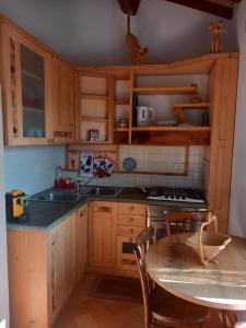 una cucina con mobili in legno, un tavolo e un lavandino di Appartamento Dolce Sguardo su Orvieto a Orvieto Altre 28 foto
