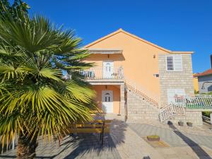 a house with a palm tree in front of it at Apartments Alma in Orebić +17 photos