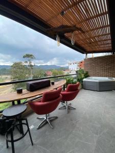 a patio with a table and chairs and a view at San Telmo - Guatape with Hot Tube in Guatapé