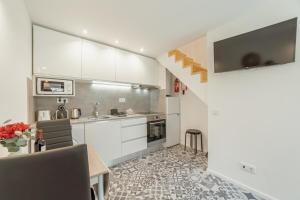 BicasにあるCedofeita Loft by Hostyの白いキャビネットとテーブルと椅子のあるキッチン