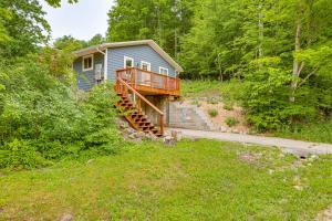 ein blaues Haus mit einer Terrasse und Treppen in einem Hof in der Unterkunft Secluded Suttons Bay Retreat with Fire Pit! in Suttons Bay