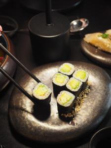 a plate of sushi on a table with a spoon at Aparts Hotel Radom in Radom