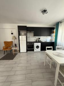 a kitchen with black cabinets and a white appliance at Kypa rooms 50 steps to the beach in Larnaca