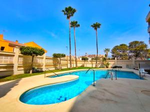 a swimming pool with trees and palm trees at Ático con Terrazas y Piscina en Aguadulce in Roquetas de Mar