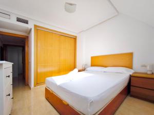 a bedroom with a large bed with a wooden headboard at Ático con Terrazas y Piscina en Aguadulce in Roquetas de Mar +19 photos