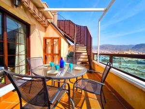a table and chairs on a balcony with a view at Ático con Terrazas y Piscina en Aguadulce in Roquetas de Mar