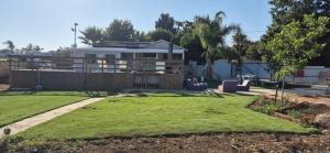 a yard with a house in the background at מצוקי גורן in Goren