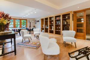 a living room with white chairs and a table at Apartaments La Neu-Mountain Lodges & Restaurant in Ordino