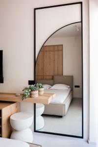 a mirror in a bedroom with a bed and a table at Samothraki Kaviri Boutique Residence in Samothráki
