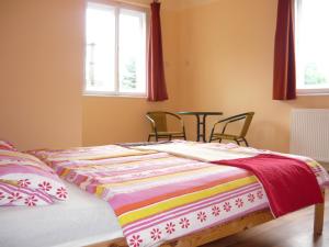 ein Bett mit einer bunten Decke darüber in der Unterkunft Börzsöny Kapuja Vendégház in Zebegény