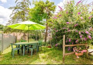 a table and chairs and an umbrella in the grass at Ciuchi House in Cantalupo Ligure