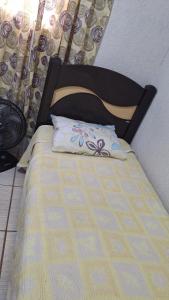 a bed with a black headboard and a pillow on it at Casa ideal in São Caetano do Sul