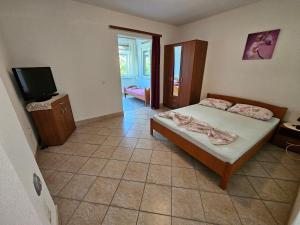 a bedroom with a bed and a flat screen tv at Apartments Alma in Orebić