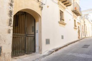 a building with a large door on the side of a street at Dimora delle Volte 2 bagni,centro storico Noto in Noto