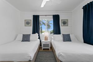 - 2 lits dans une chambre dotée de rideaux bleus dans l'établissement The Molloy - A Boutique Beach Resort, à St. Pete Beach 79 autres photos