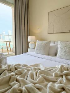 a bedroom with two beds and a large window at Luxury Boho Retreat Serene Lagoon Views in Abu Dhabi