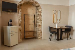 a room with a table and a refrigerator and a door at Dimora delle Volte 2 bagni,centro storico Noto in Noto