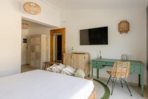 een slaapkamer met een bed, een bureau en een tv bij Nu Aria Taunus Relais in Numana