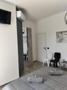 a white bedroom with a bed and a mirror at La Fenice 40 in Numana +33 photos
