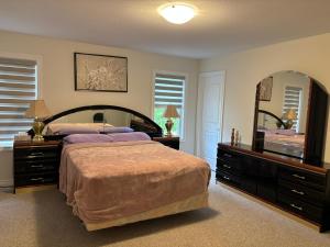 ein Schlafzimmer mit einem großen Bett und einem großen Spiegel in der Unterkunft Whole House 4 Bedrooms 6 beds 3 bath family friendly Quite and relaxation area in Gravenhurst