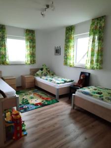 ein kleines Schlafzimmer mit zwei Betten und einem Teppich in der Unterkunft Ferienwohnung Nähe Legoland Günzburg 86 qm mit Balkon in Burtenbach