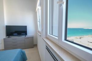 a bedroom with a window with a view of the beach at Luxury Penthouses Romeo e Giulietta by GG Apartments in Gallipoli