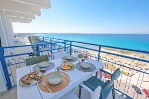 a table with food and the ocean in the background at Luxury Penthouses Romeo e Giulietta by GG Apartments in Gallipoli