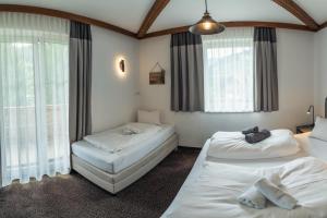 two beds in a room with windows at Landhaus Flasch in Wagrain +77 photos