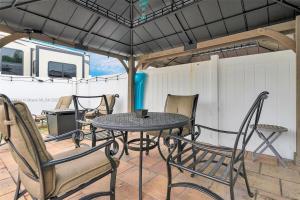 a table and chairs under an umbrella on a patio at Family Luxury Rentals - 1111 in Hypoluxo