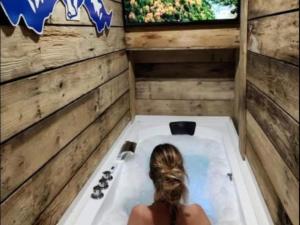 a woman sitting in a bath tub with a window at Le Cent Quarante in Spa