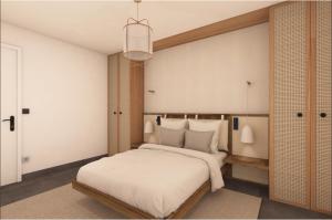 a bedroom with a large bed with white sheets at L'Astrolabe in Vieux-Fort