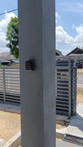 un pilier en béton avec une boîte sur le côté d'une rue dans l'établissement Minimalist Homestay Dungun, à Kampong Sura Tengah 4 autres photos