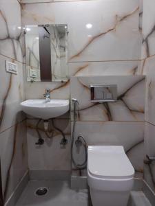 a bathroom with a white toilet and a sink at Hotel C G Newly Built 2 Mins From Connaught Place and Railway Station & 5 Mins From VFS Shivaji Stadium Metro Station in New Delhi