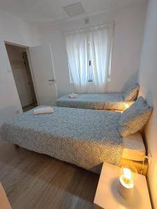 two beds in a small room with a table at Casa do Rio - Apartment Earth in Portimão